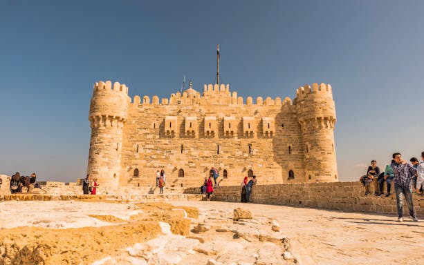 Citadel of Qaitbay in Alexandria with tourists exploring the historic site.