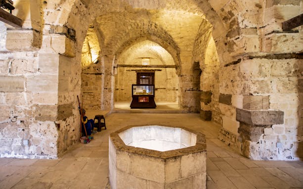 Underground chamber in Alexandria with stone walls and an octagonal well.