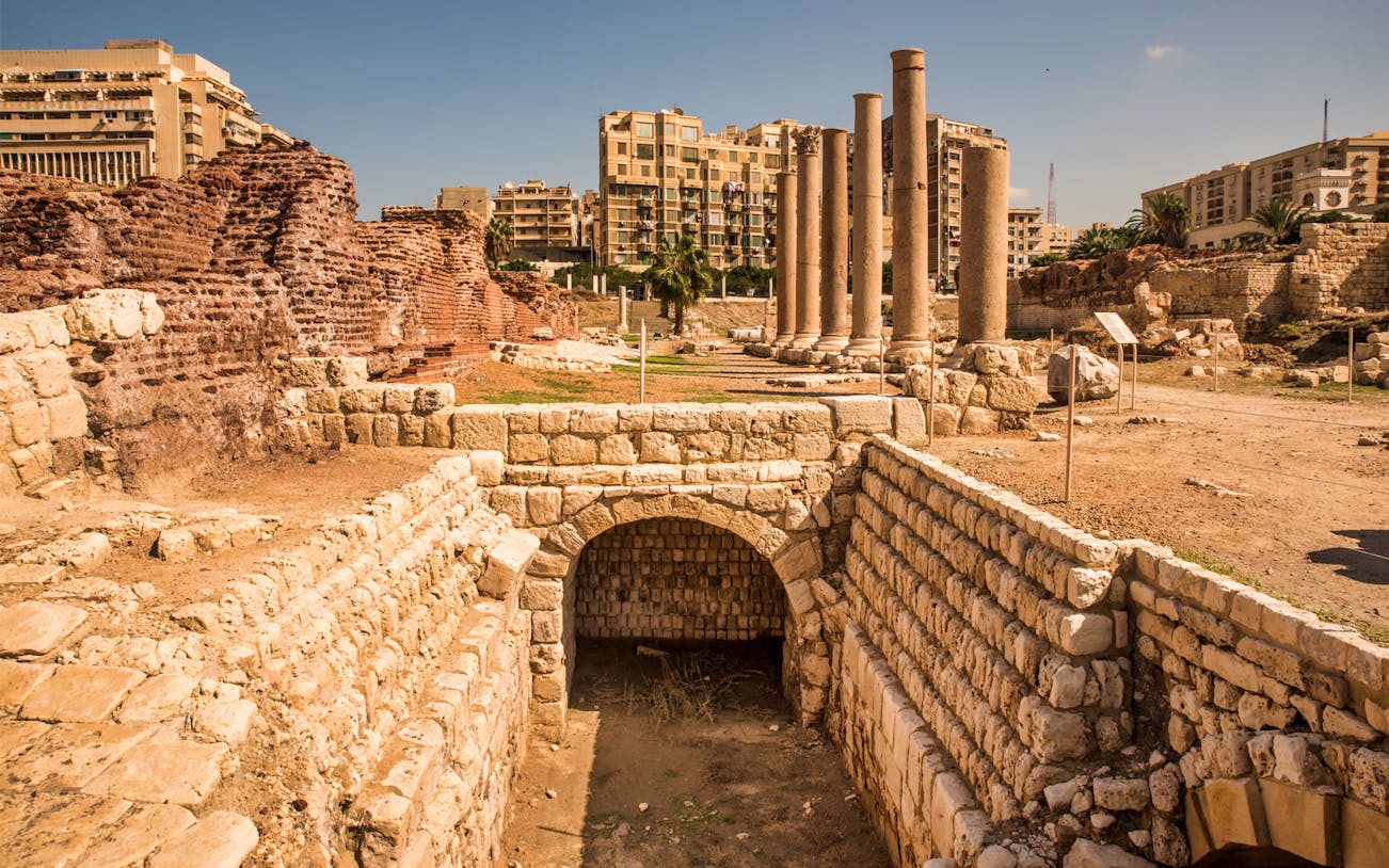 Roman ruins with columns in Alexandria, Egypt, part of a full-day historical tour from Cairo.