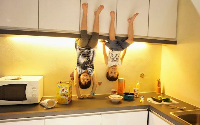 Children appearing upside down in a kitchen at Upside Down House Melaka.