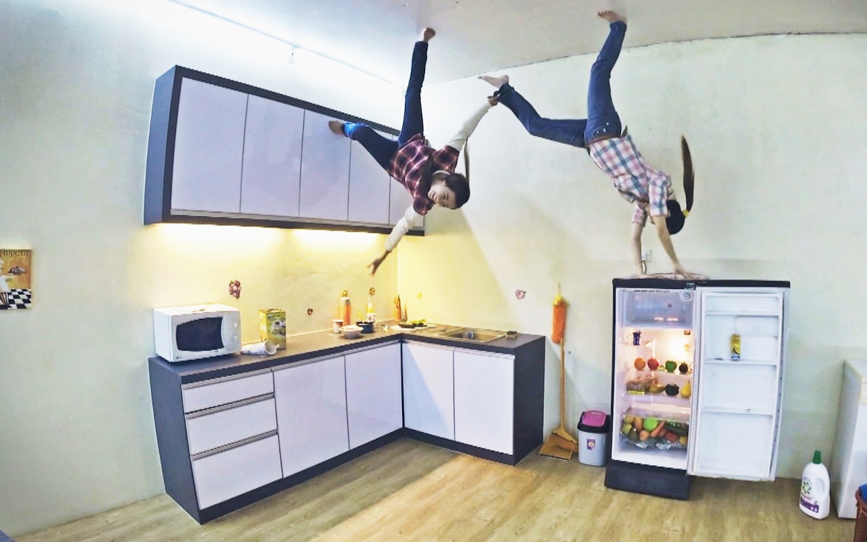 Visitors exploring the Upside Down House kitchen in Melaka, Malaysia.