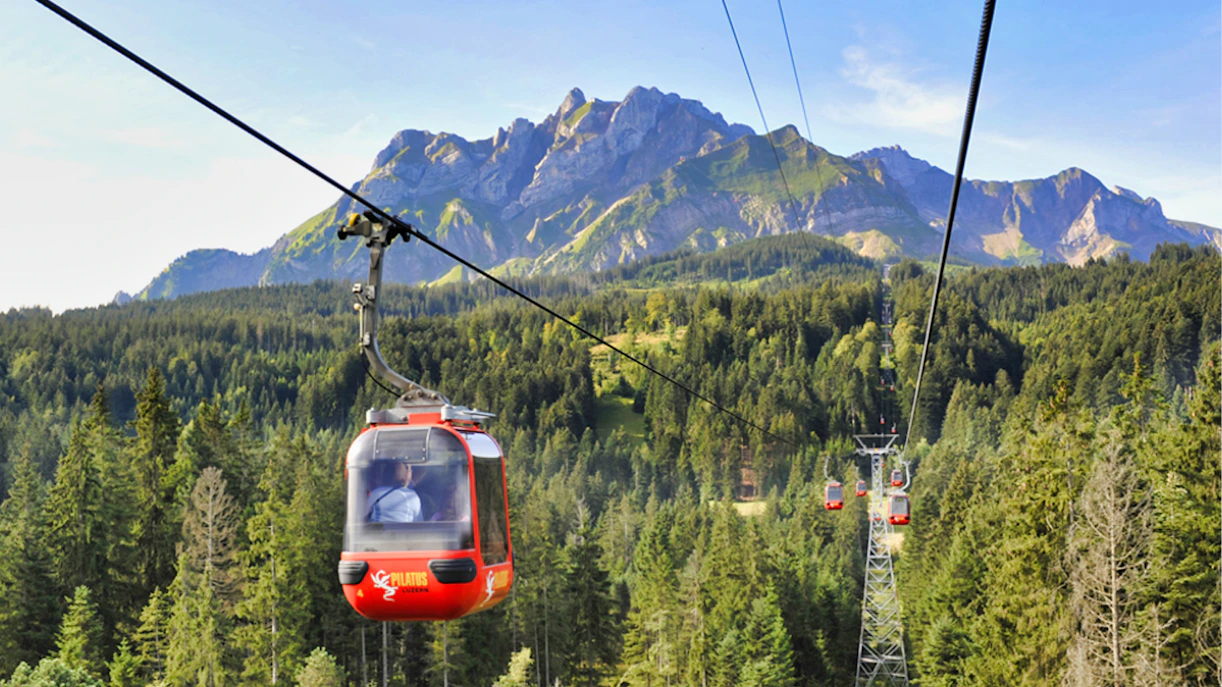 Cable car ascending Mount Pilatus with forest and mountain view, part of guided tour from Zürich.