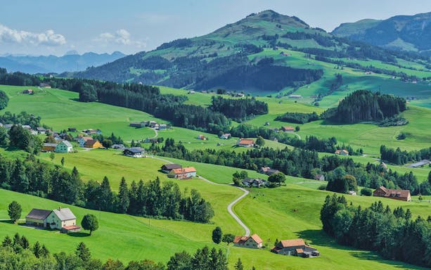 Scenic view of Appenzell's rolling hills and scattered farmhouses, part of a guided tour from Zürich.
