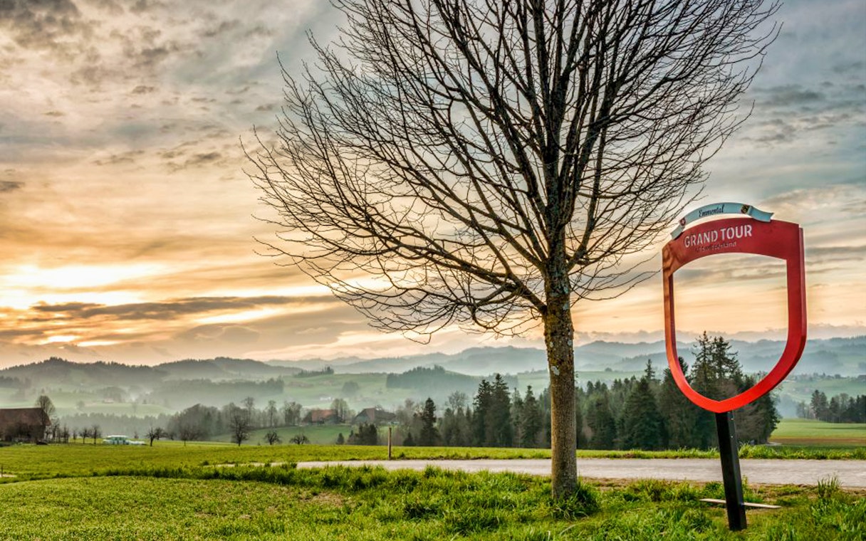 Grand Tour sign and tree with Emmental landscape near Bern, Switzerland.