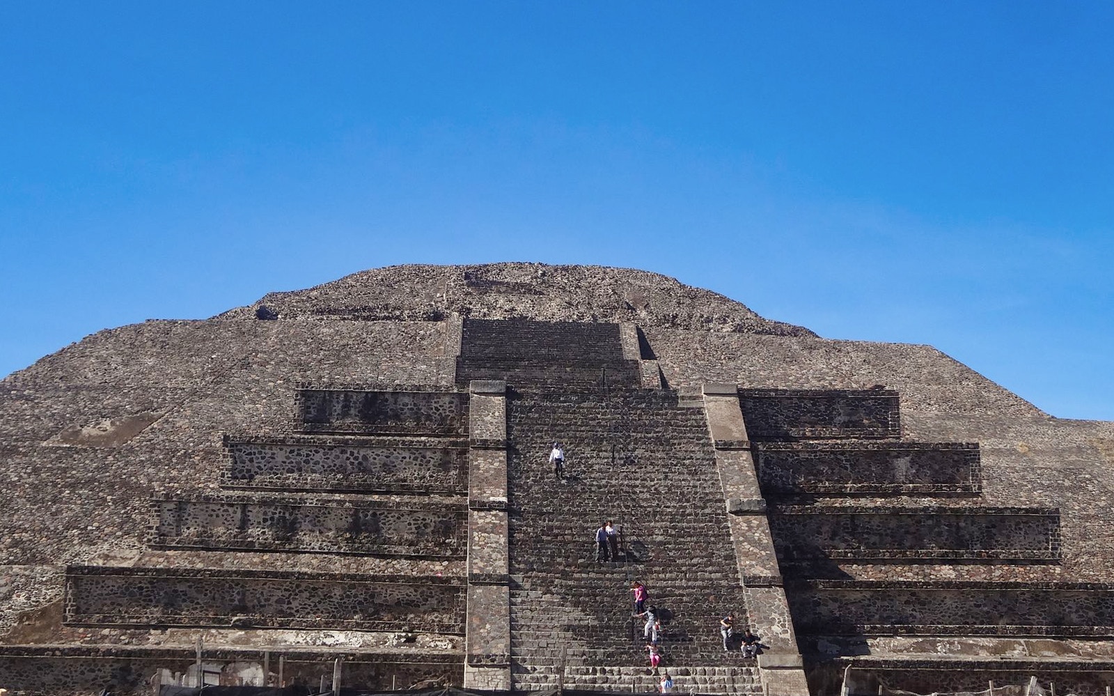Pyramid of the Sun at Teotihuacan with visitors climbing steps, Mexico.