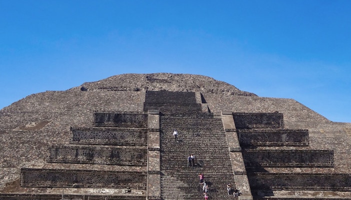 Pyramid of the Sun at Teotihuacan with visitors climbing steps, Mexico.