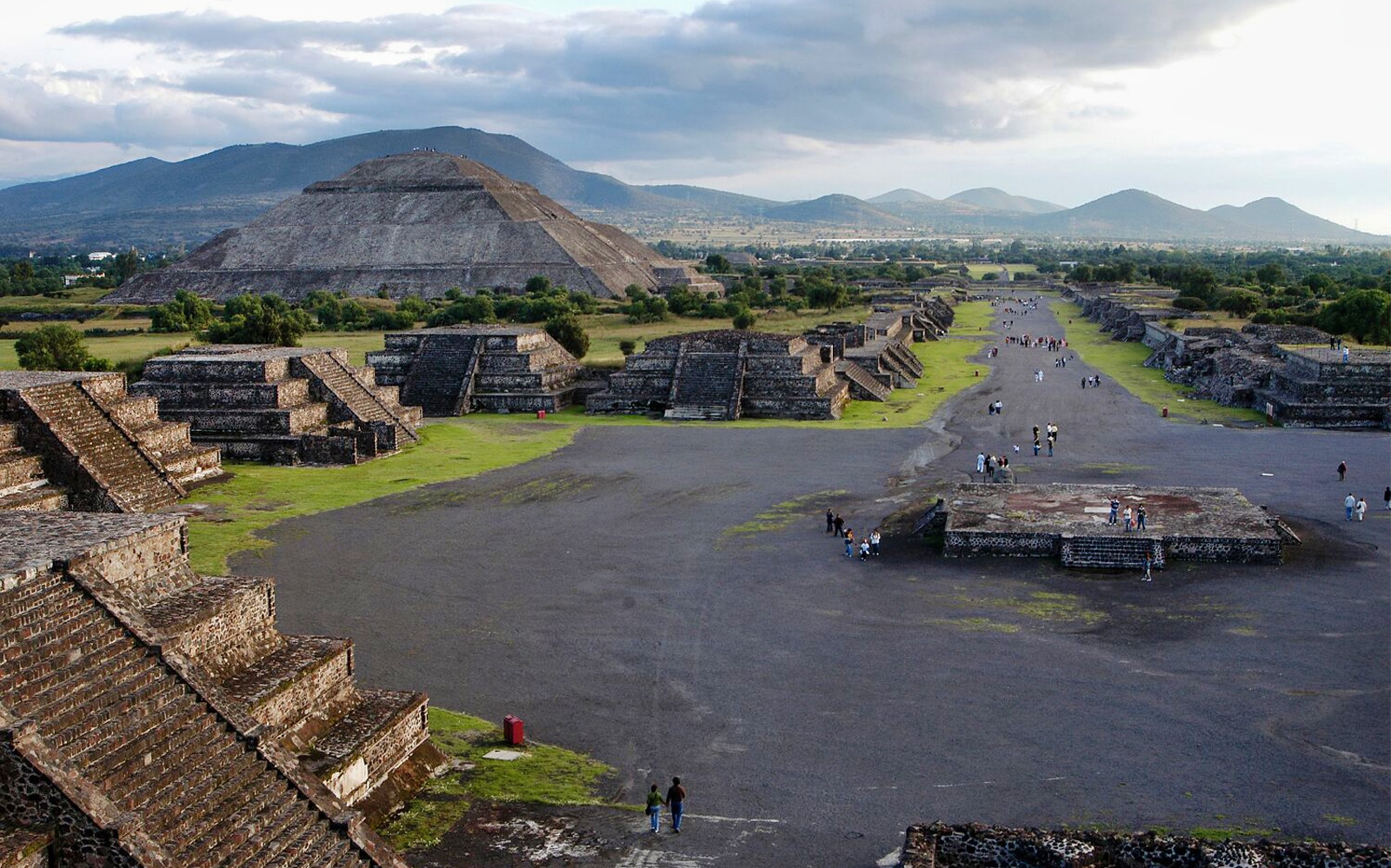 Teotihuacan pyramids and Avenue of the Dead with visitors exploring the ancient site in Mexico.