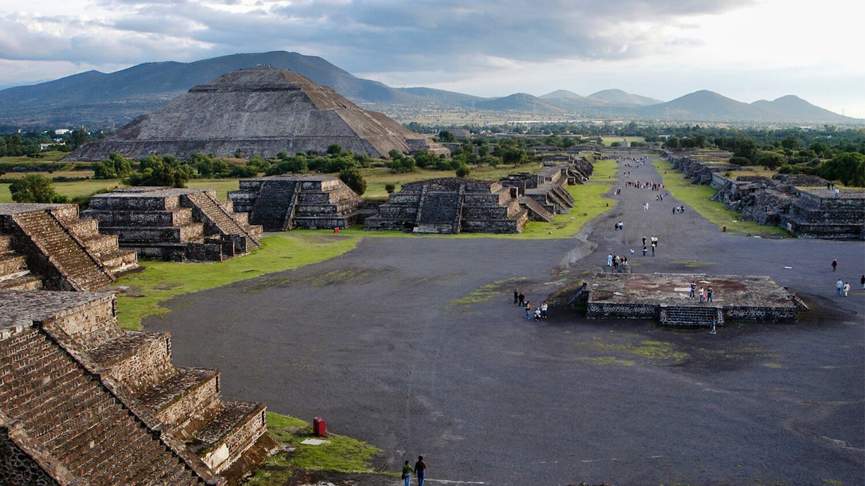 Teotihuacan pyramids and Avenue of the Dead with visitors exploring the ancient site in Mexico.
