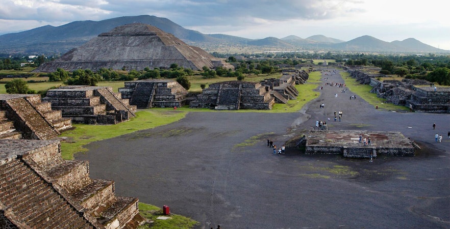 Teotihuacan pyramids and Avenue of the Dead with visitors exploring the ancient site in Mexico.