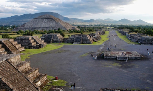 Teotihuacan pyramids and Avenue of the Dead with visitors exploring the ancient site in Mexico.
