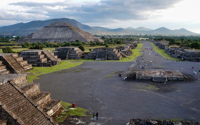 Teotihuacan pyramids and Avenue of the Dead with visitors exploring the ancient site in Mexico.