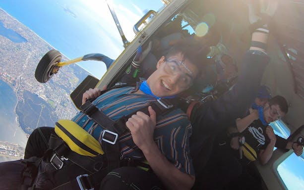 Tandem skydiver preparing to jump from plane over Perth, Australia.