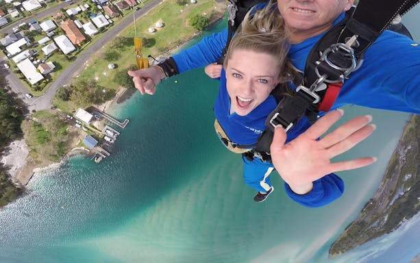 Tandem skydive over Hunter Valley, capturing aerial view of coastline and residential area.