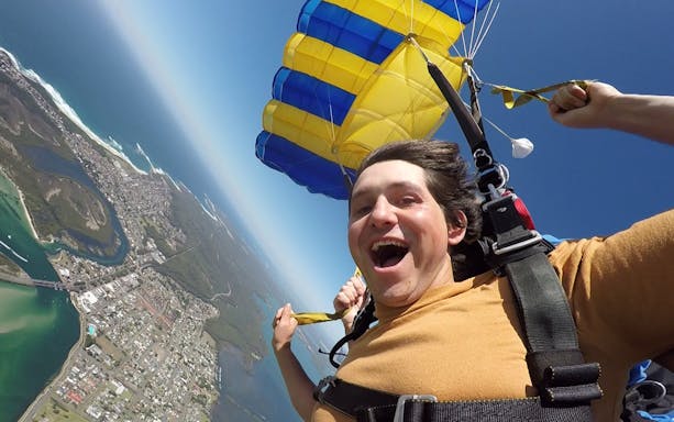 Tandem skydiver over Hunter Valley with parachute open, 15,000ft view of landscape.