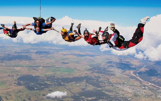 Skydivers in freefall over Hunter Valley, Australia, during a tandem skydive at 15,000 feet.