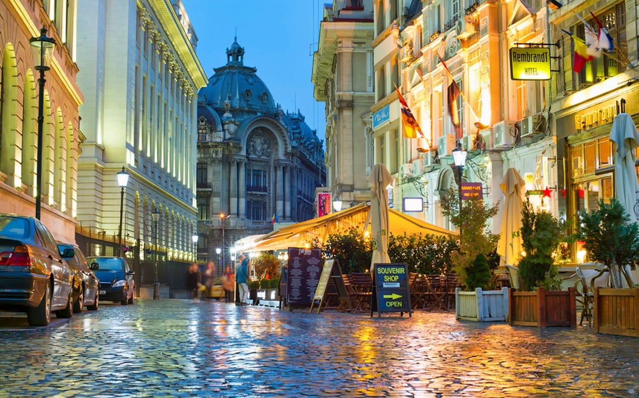 Old Town Bucharest street with cafes and historic architecture during a walking food tour.