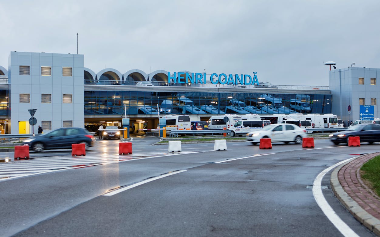 Henri Coandă Airport entrance with cars and buses, Bucharest airport transfer.