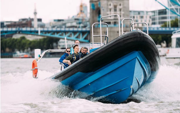 High-speed boat tour on the Thames River with passengers enjoying the ride.