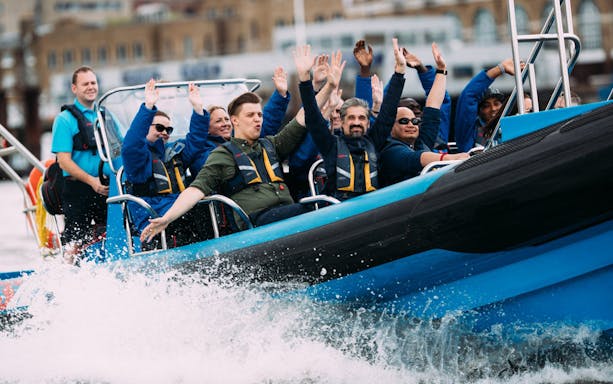 Group enjoying a high-speed boat ride with water splashing.