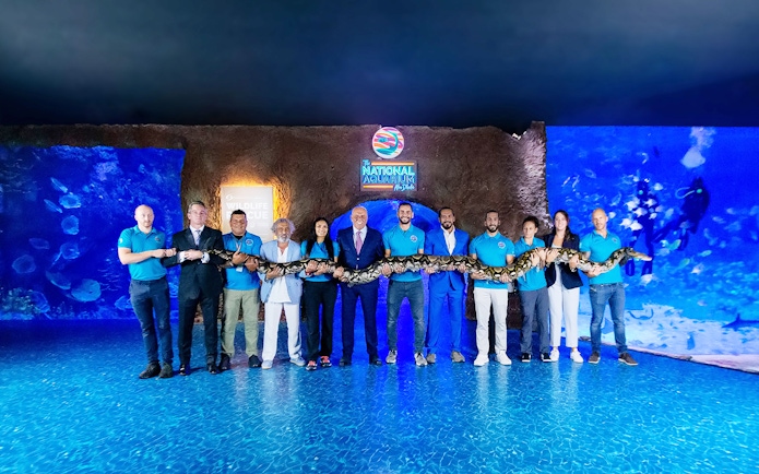 Staff holding a large snake at the National Aquarium Abu Dhabi.
