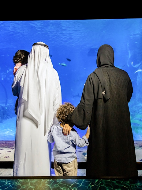 Family viewing marine life at National Aquarium Abu Dhabi.
