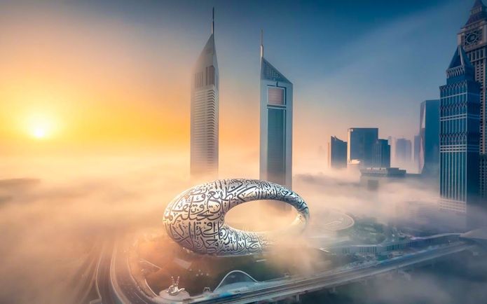 Museum of the Future in Dubai surrounded by skyscrapers and morning fog.