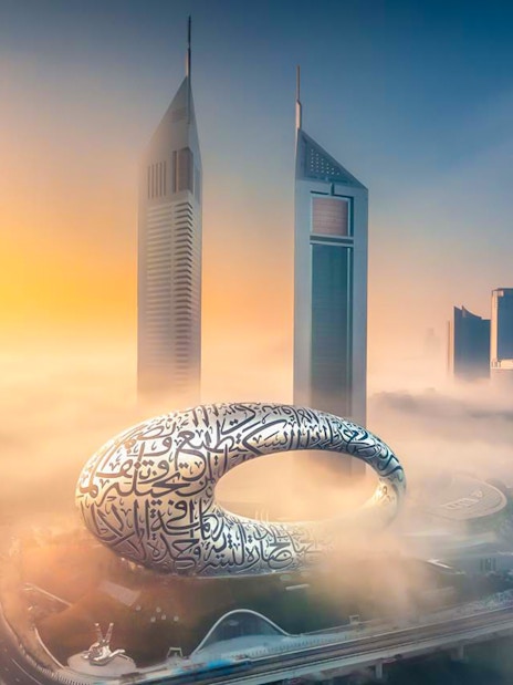 Museum of the Future in Dubai surrounded by skyscrapers and morning fog.