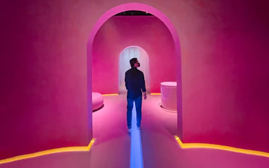 Person exploring futuristic pink-lit room at Museum of the Future, Dubai.