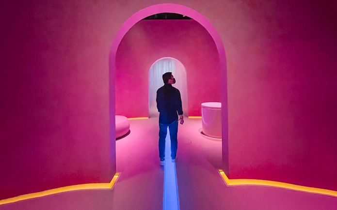 Person exploring futuristic pink-lit room at Museum of the Future, Dubai.