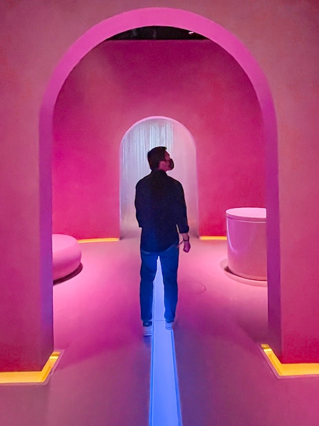 Person exploring futuristic pink-lit room at Museum of the Future, Dubai.