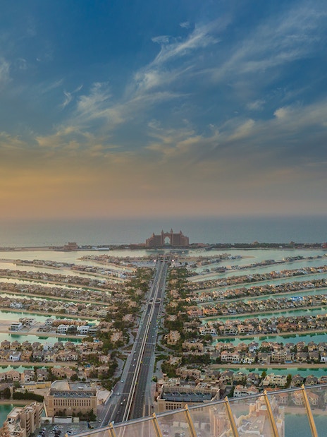 Aerial view of Palm Jumeirah in Dubai at sunset, featuring Atlantis The Palm hotel.