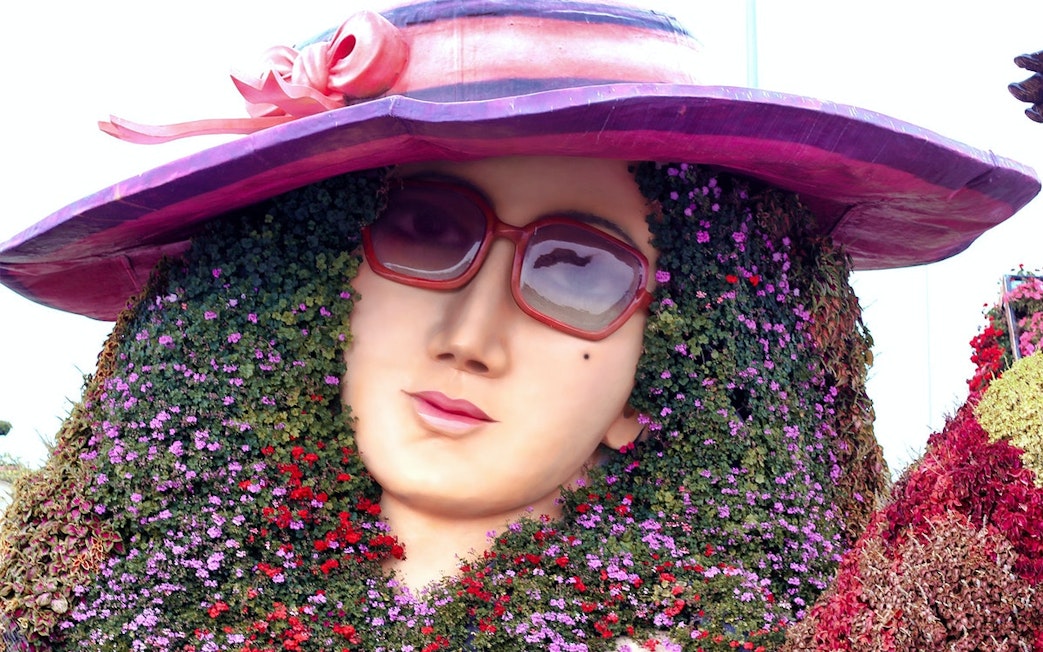 Floral sculpture of a woman's face with sunglasses at Dubai Miracle Garden.
