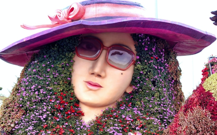 Floral sculpture of a woman's face with sunglasses at Dubai Miracle Garden.