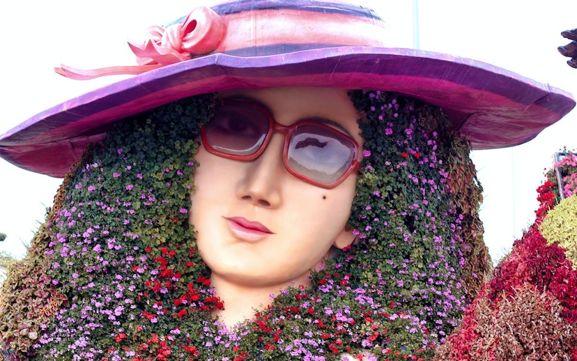 Floral sculpture of a woman's face with sunglasses at Dubai Miracle Garden.