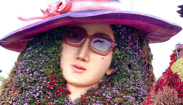 Floral sculpture of a woman's face with sunglasses at Dubai Miracle Garden.