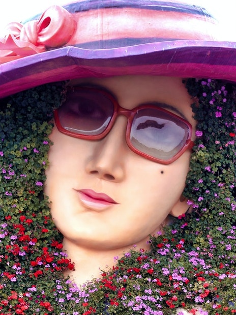 Floral sculpture of a woman's face with sunglasses at Dubai Miracle Garden.