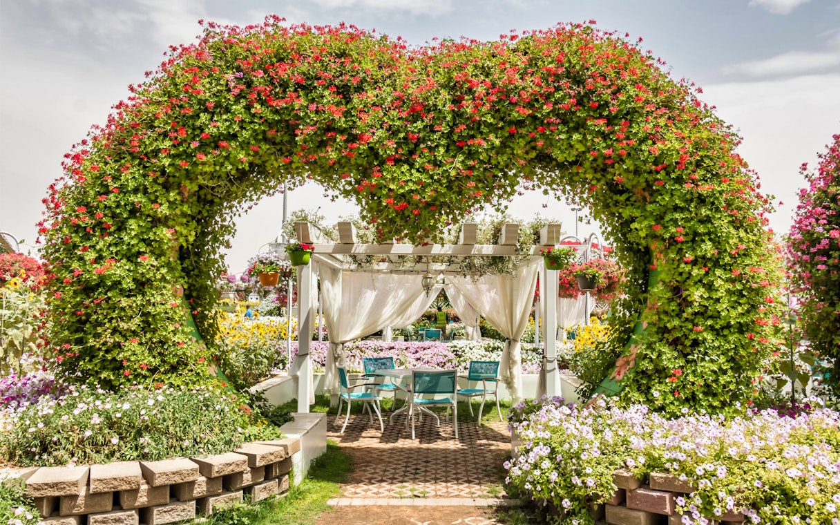 Floral archway and seating area at Dubai Miracle Garden.