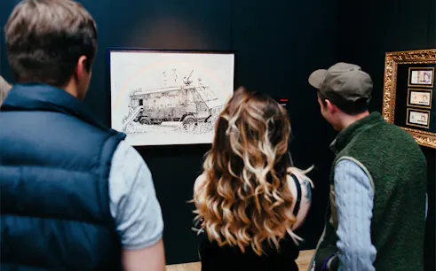 Visitors viewing Banksy artwork at an exhibition.