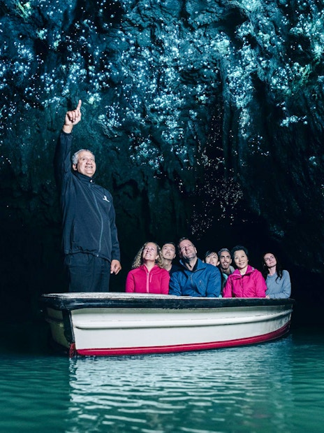 Tourists on a boat admire glowworms in Waitomo Caves, Auckland.