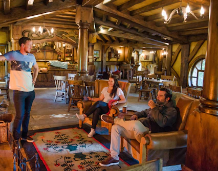 Visitors relaxing inside the Green Dragon Inn at Hobbiton Movie Set, New Zealand.