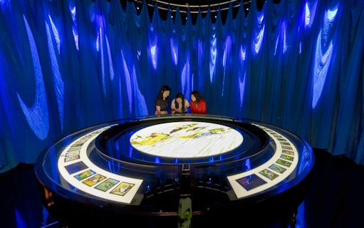 Visitors interact with a display at the Art Science Museum's STAR WARS™ Identities exhibition.