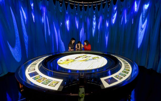Visitors interact with a display at the Art Science Museum's STAR WARS™ Identities exhibition.