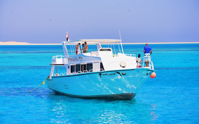 Boat on clear blue waters during Half Day Giftun Island Tour with Lunch.