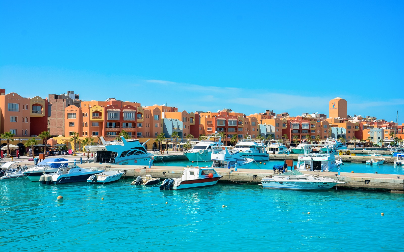 Marina with boats and colorful buildings in Hurghada City.