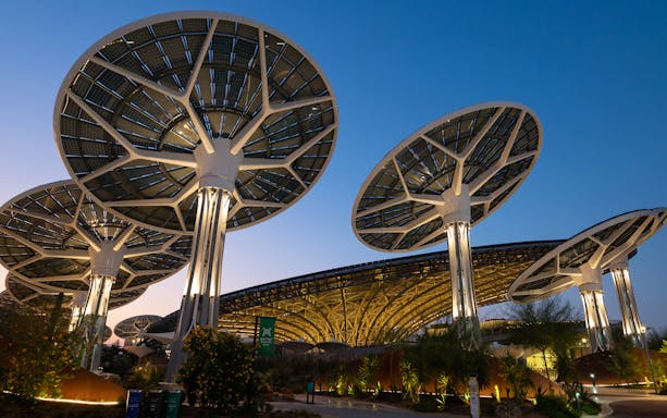 Solar panel structures at Dubai Expo 2020 site during twilight.
