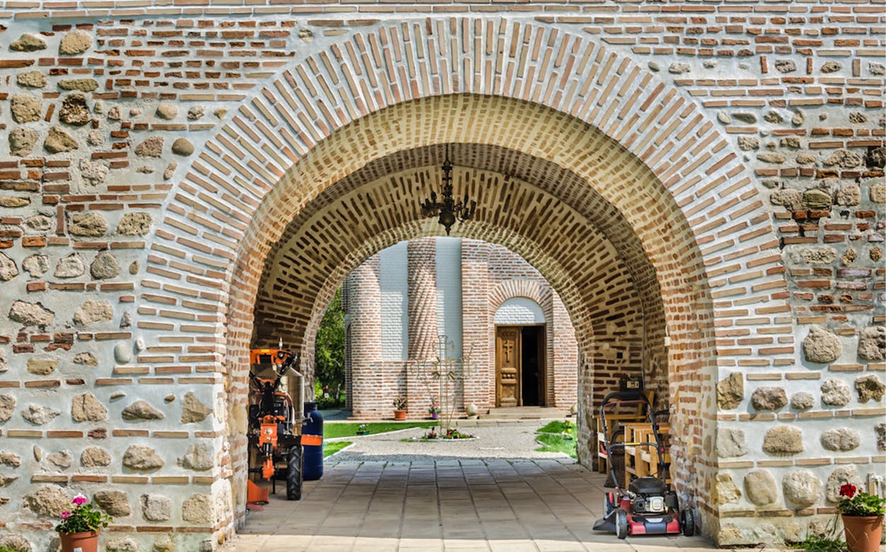 Stone archway leading to a historic building in Bucharest on a private tour.