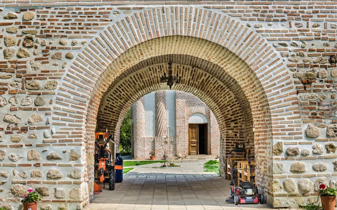 Stone archway leading to a historic building in Bucharest on a private tour.