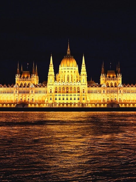 Illuminated Parliament Building at night, Bucharest sightseeing tour.