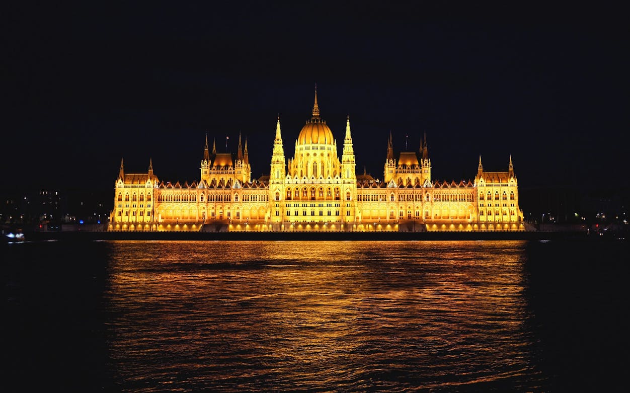 Illuminated Parliament Building at night, Bucharest sightseeing tour.