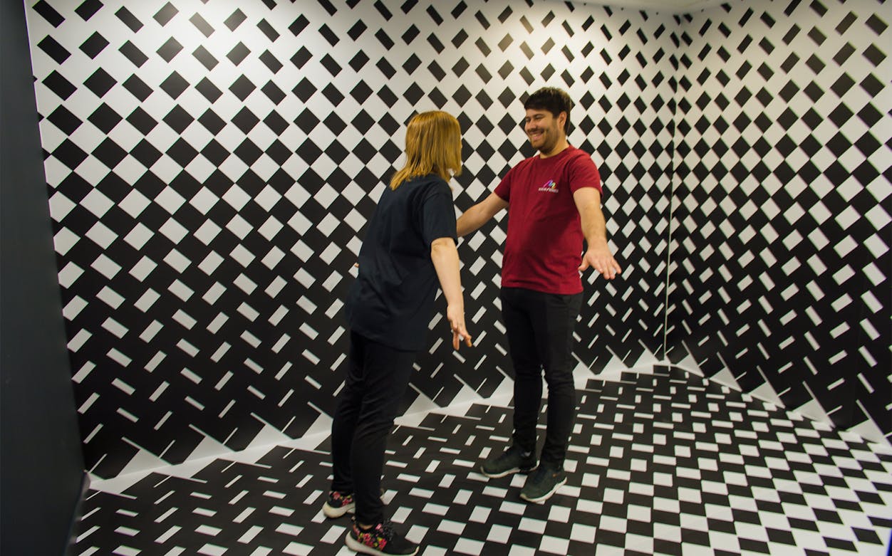 Visitors interacting in an optical illusion room at Museum of Senses, Bucharest.